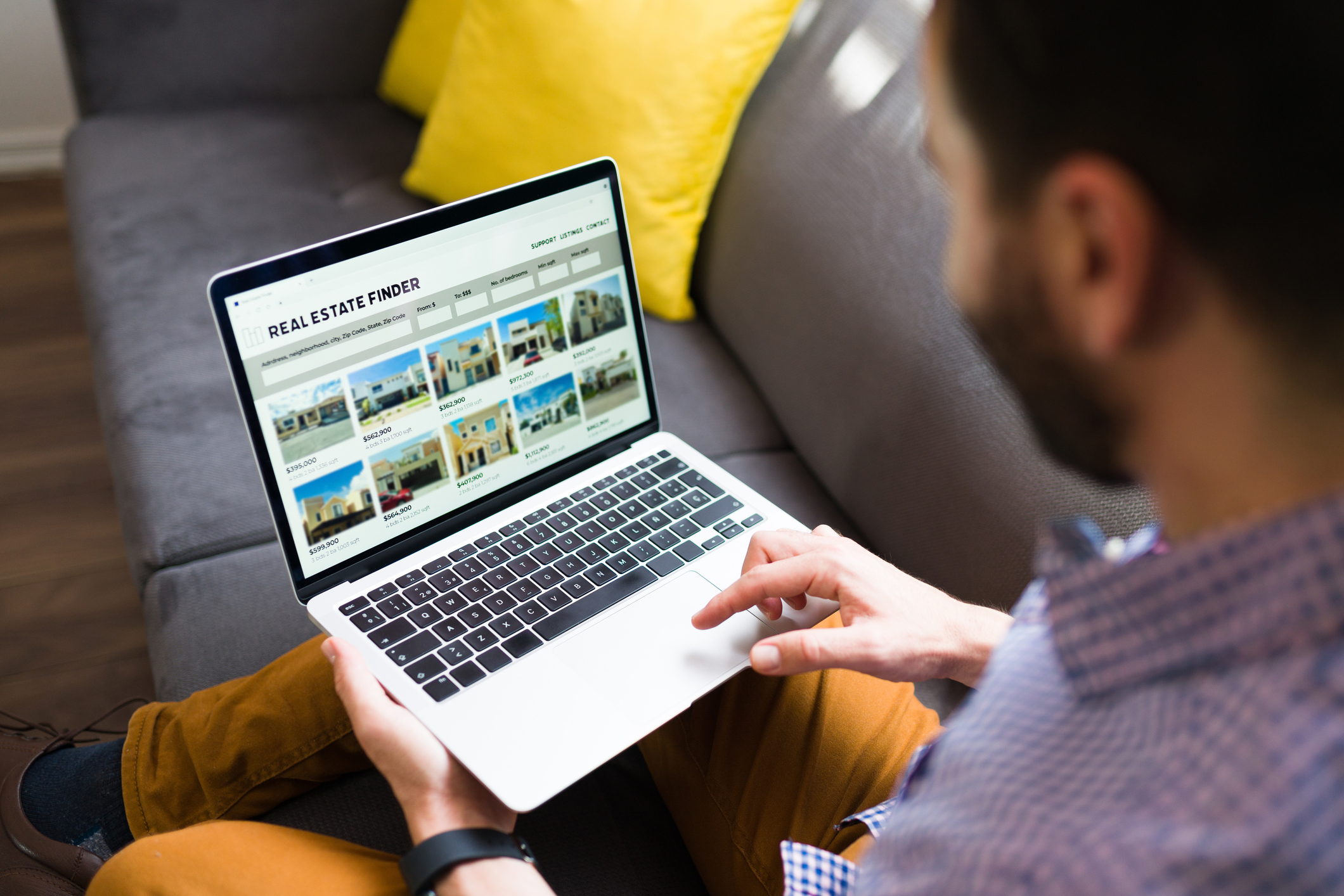 A person is looking at real estate listing photos on a laptop.