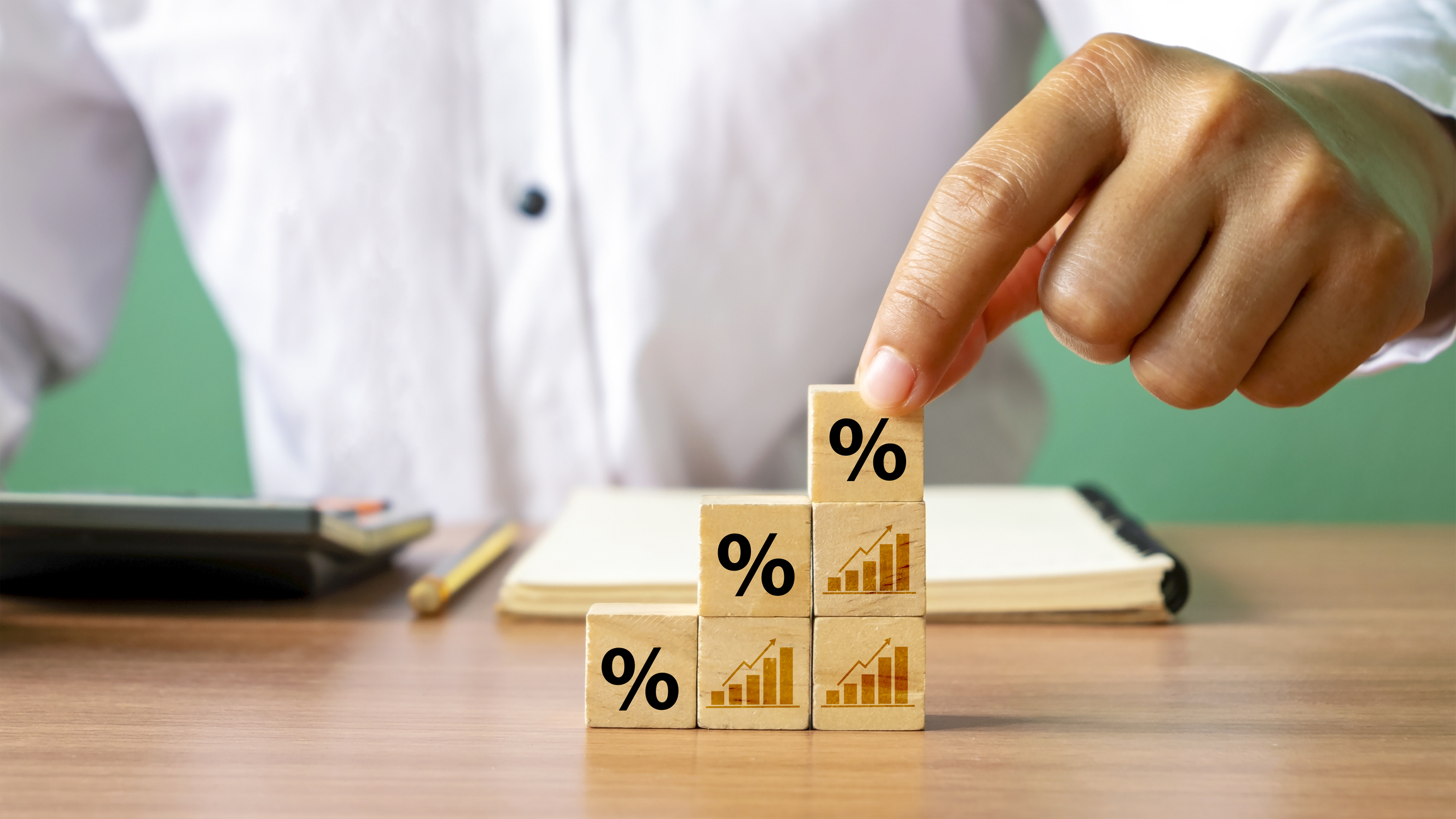Person using toy building blocks to represent upward growth.