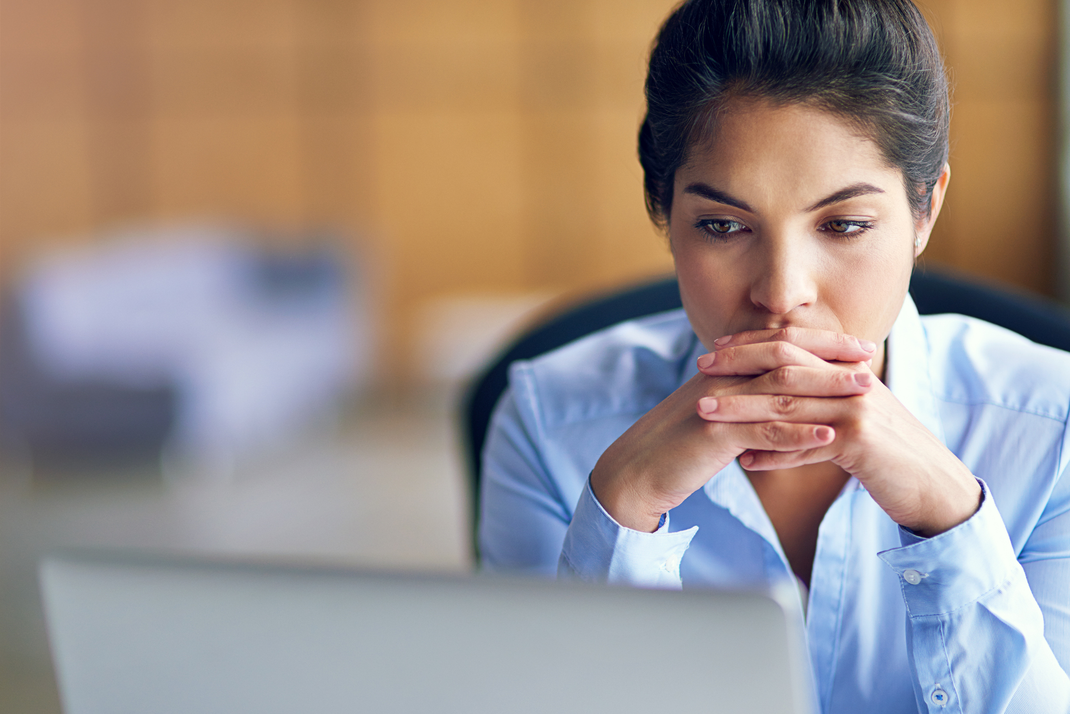 Person looking at computer deep in thought.