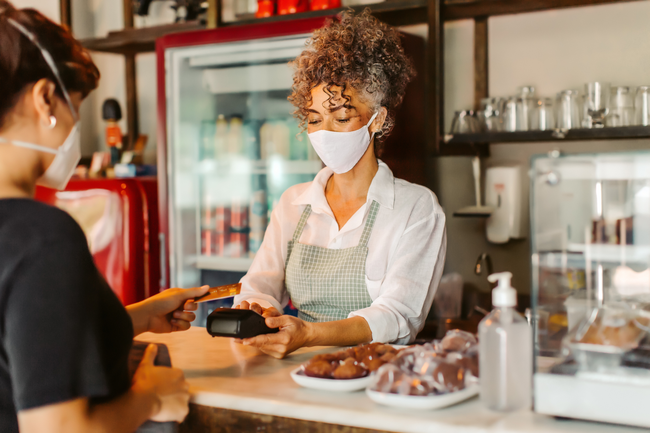 A person paying with a credit card in a cafe.