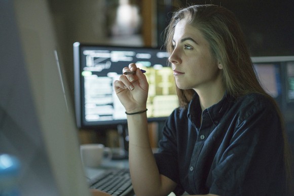 A person studying data on a monitor. 