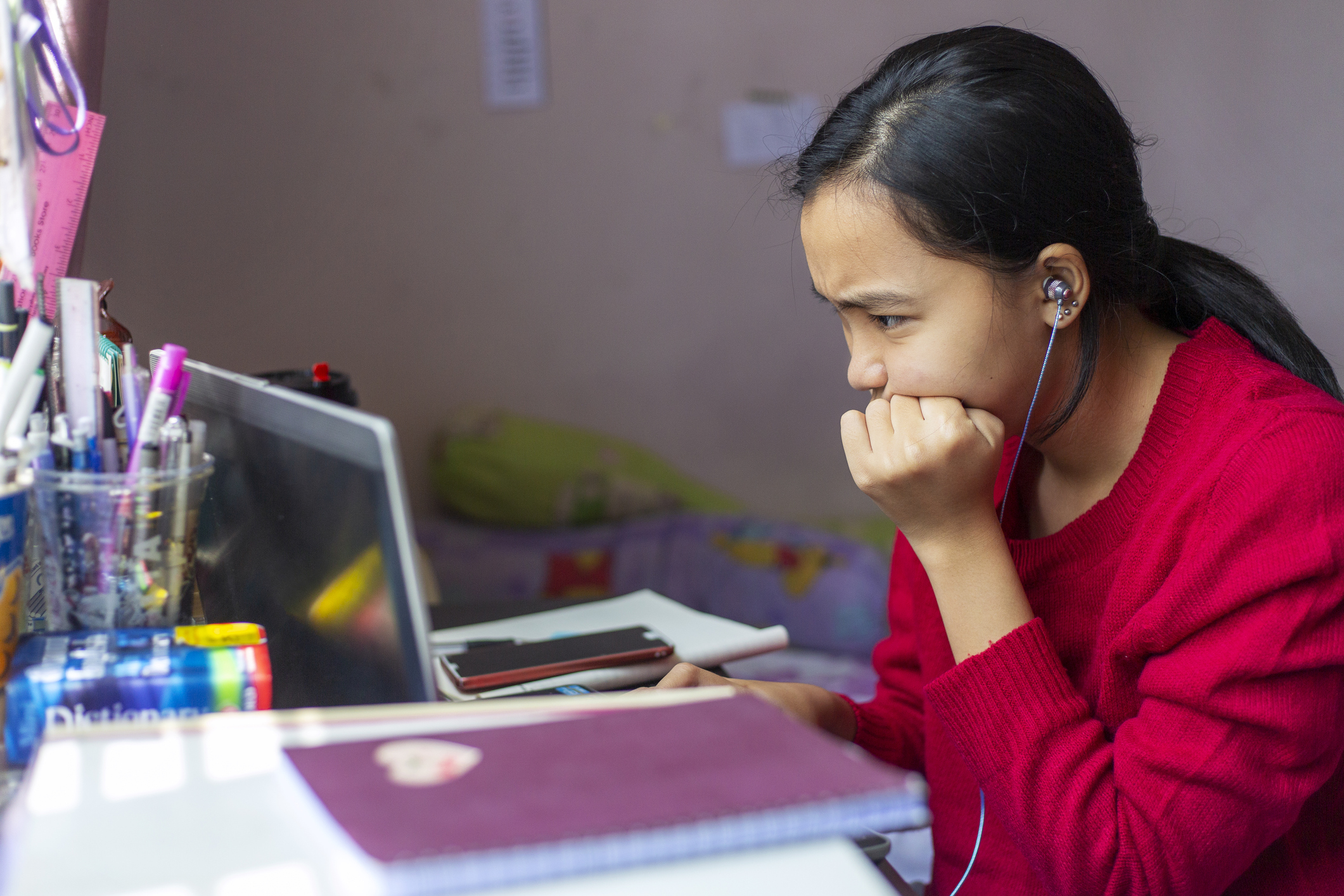 Concerned young person gazing at a laptop.