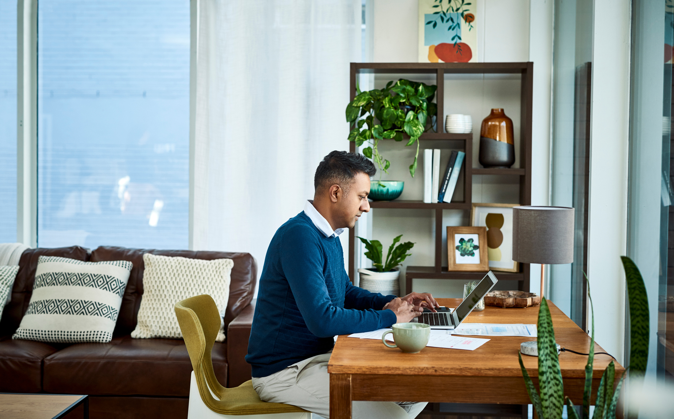A person at a laptop in a living room.