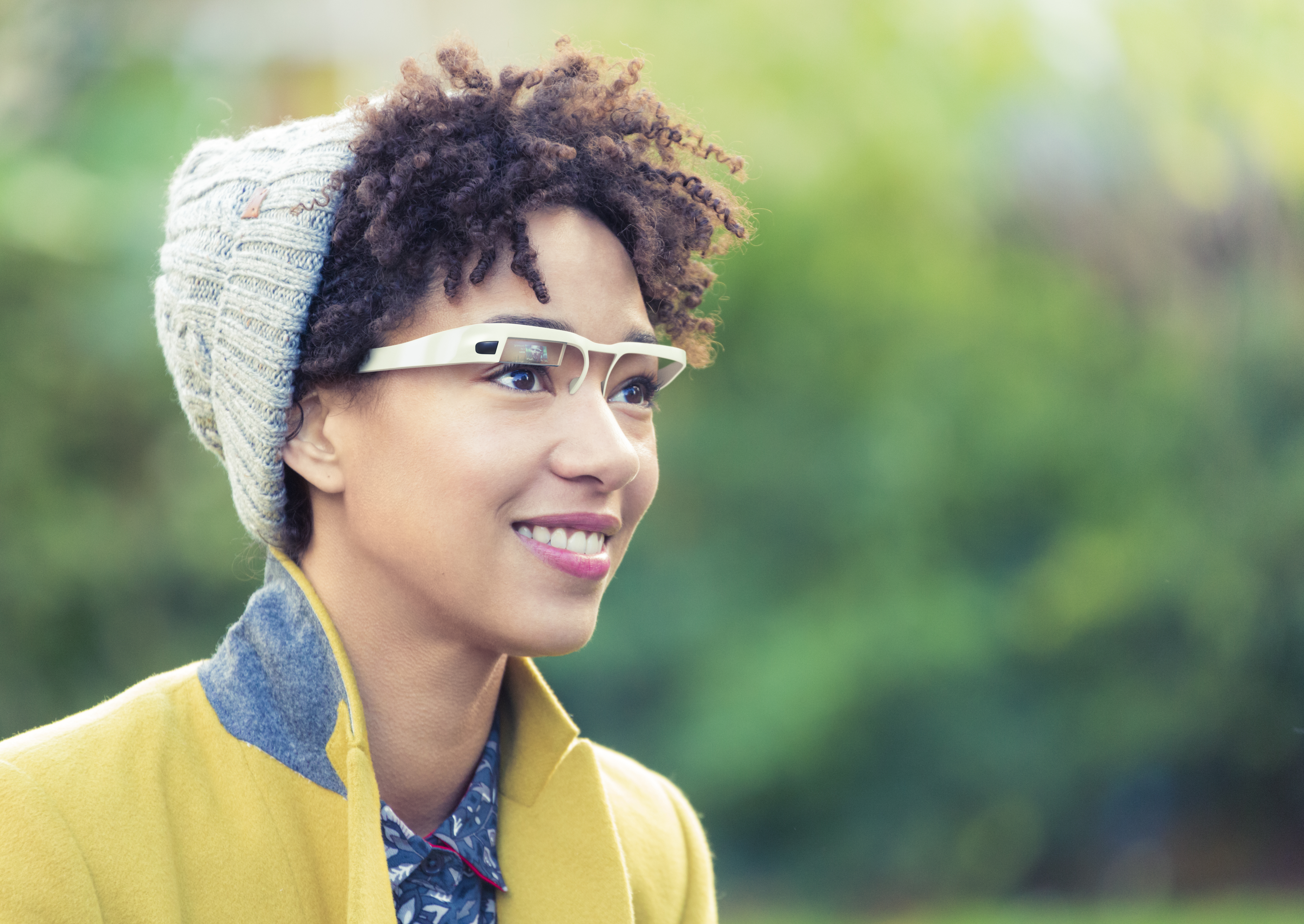 A smiling person wearing augmented reality glasses.