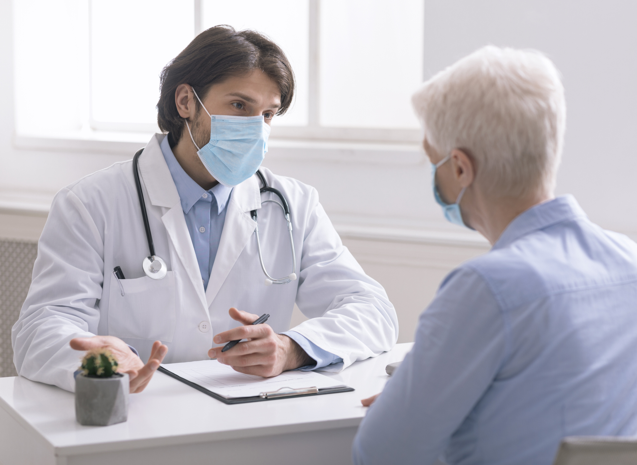 A patient and doctor talk to each other at an appointment.