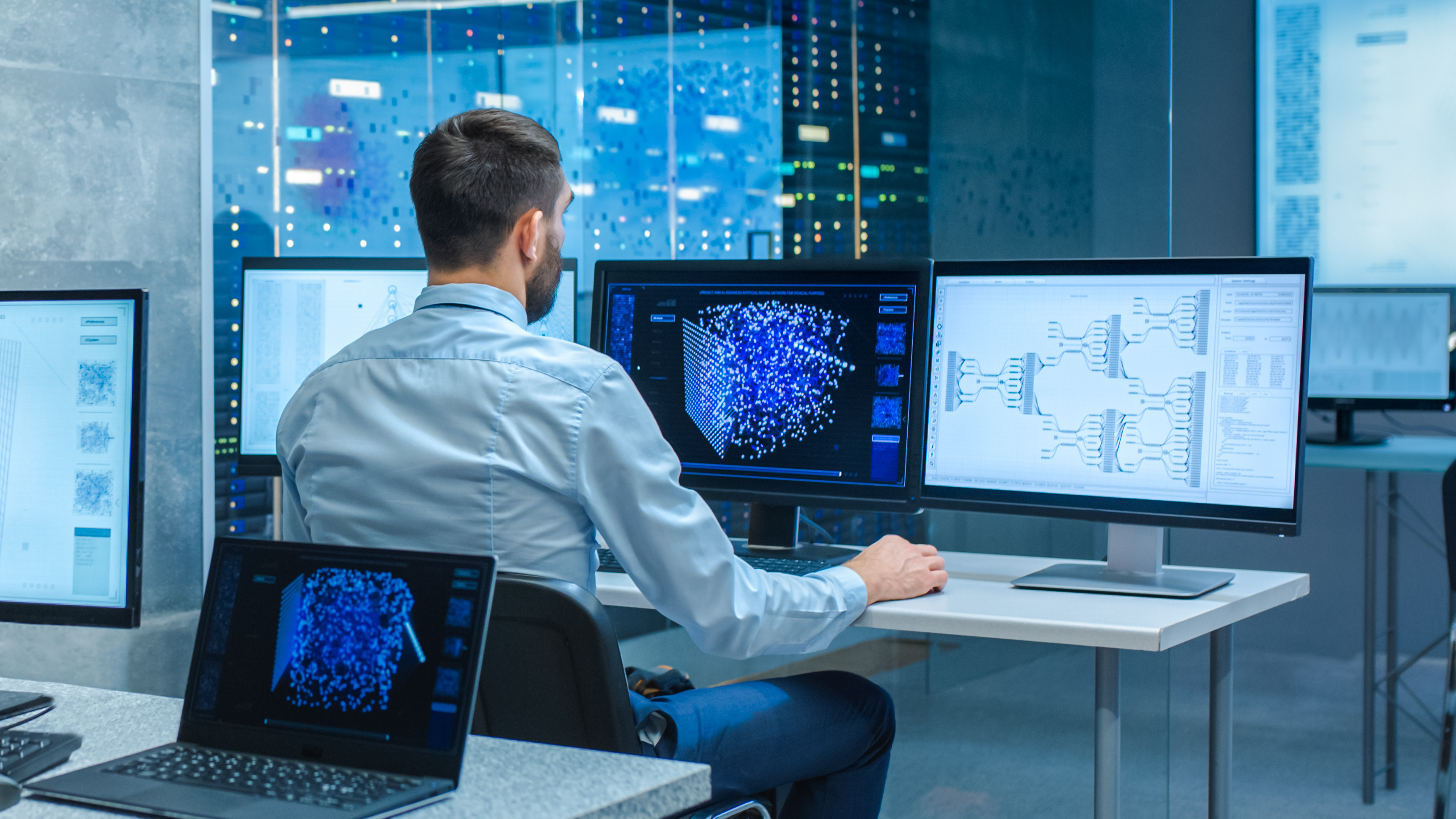 Person looking at data on computer screens.
