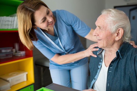 A nurse checking in on a patient at a senior housing facility. 