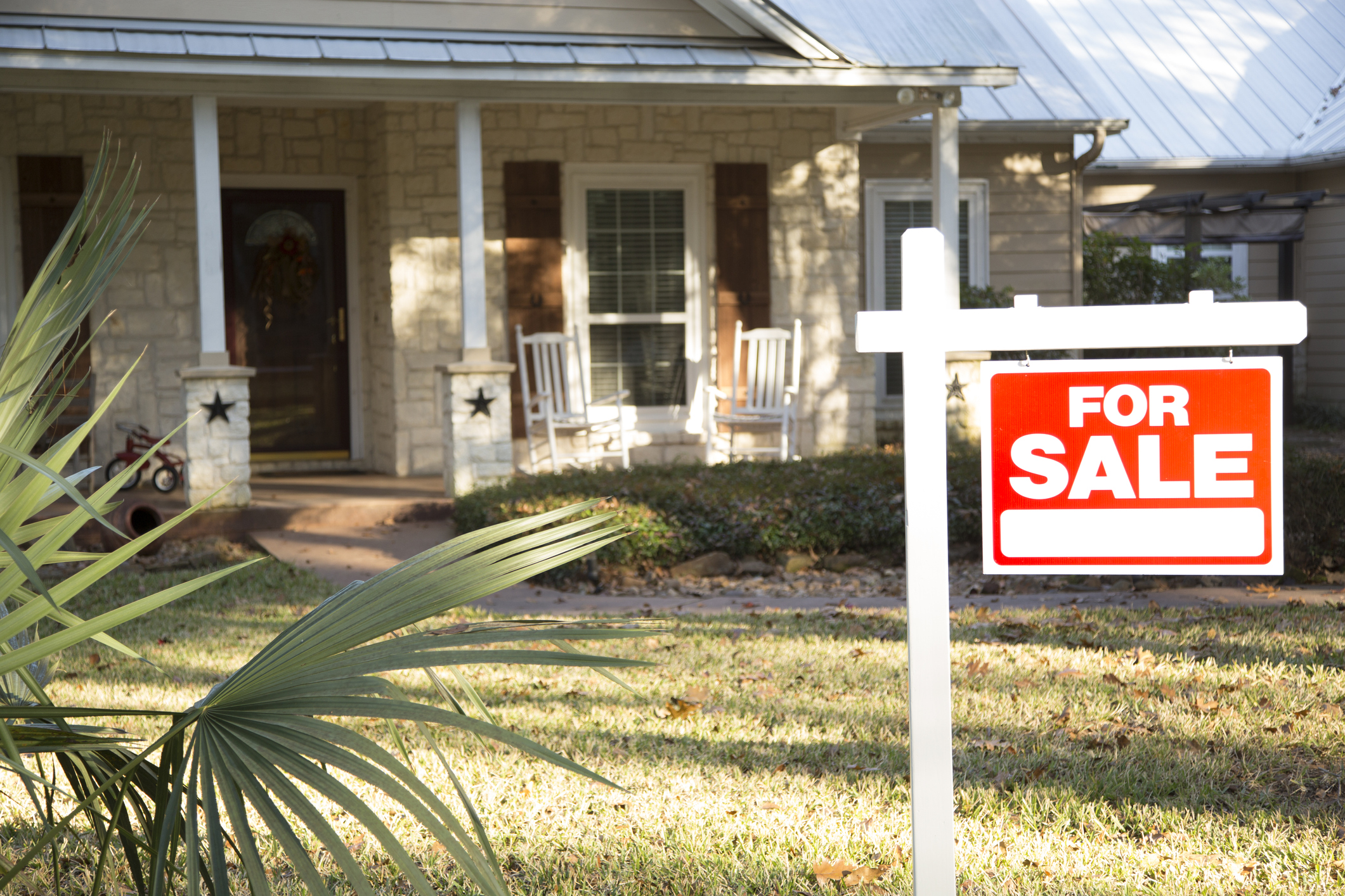 A house with a for sale sign in the front yard.