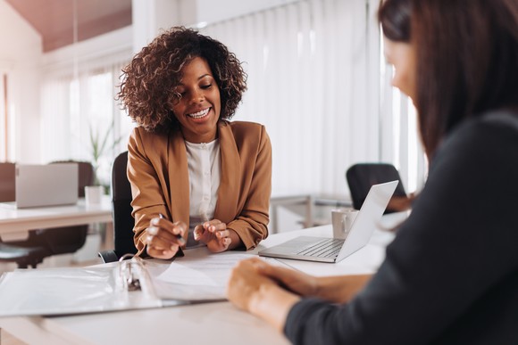 An agent meets with a client in an office.