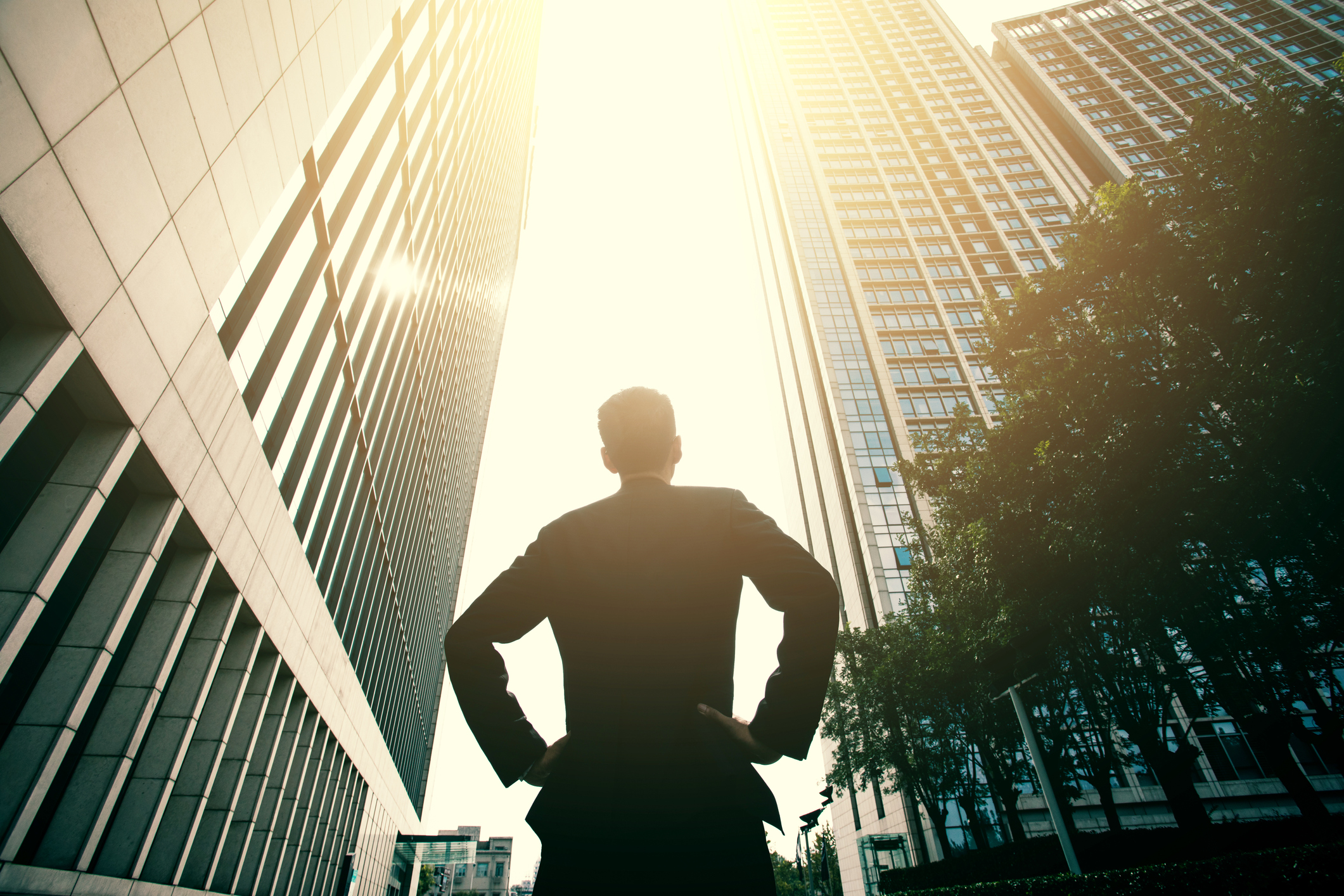 A person looking up at office buildings.