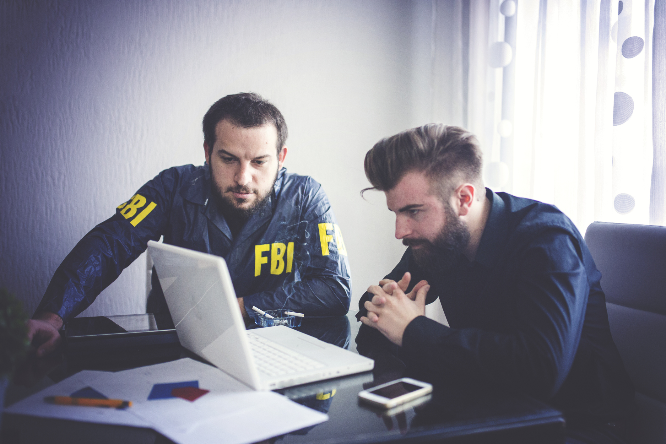 FBI agent and one other person inspecting contents on a laptop