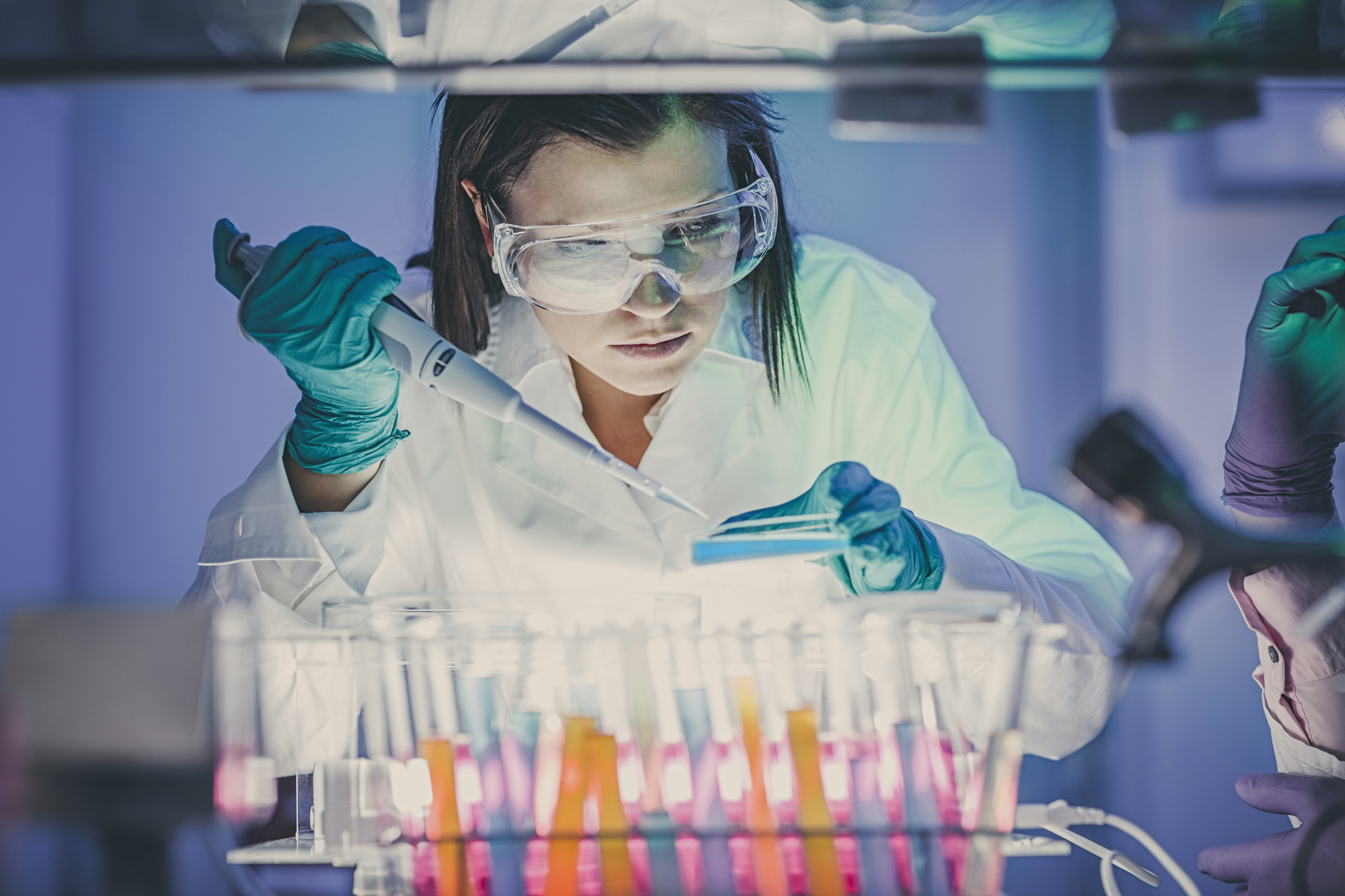 A scientist uses a pipette to extract samples in a laboratory.
