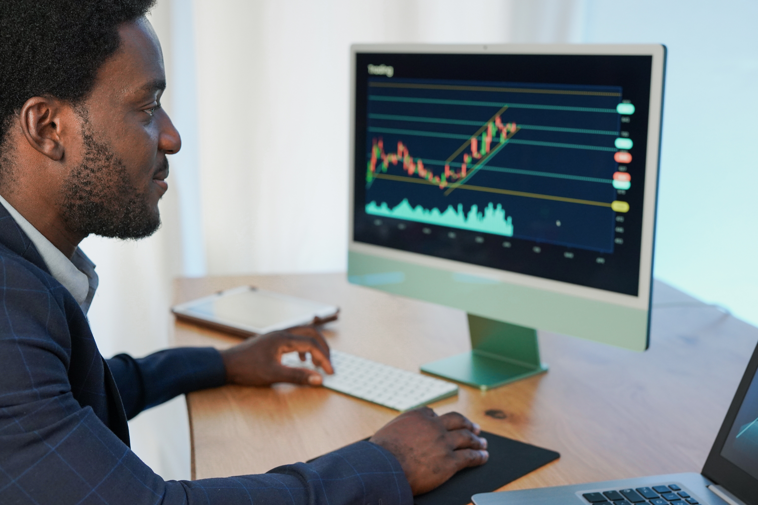 Businessperson studying stock market on desktop.
