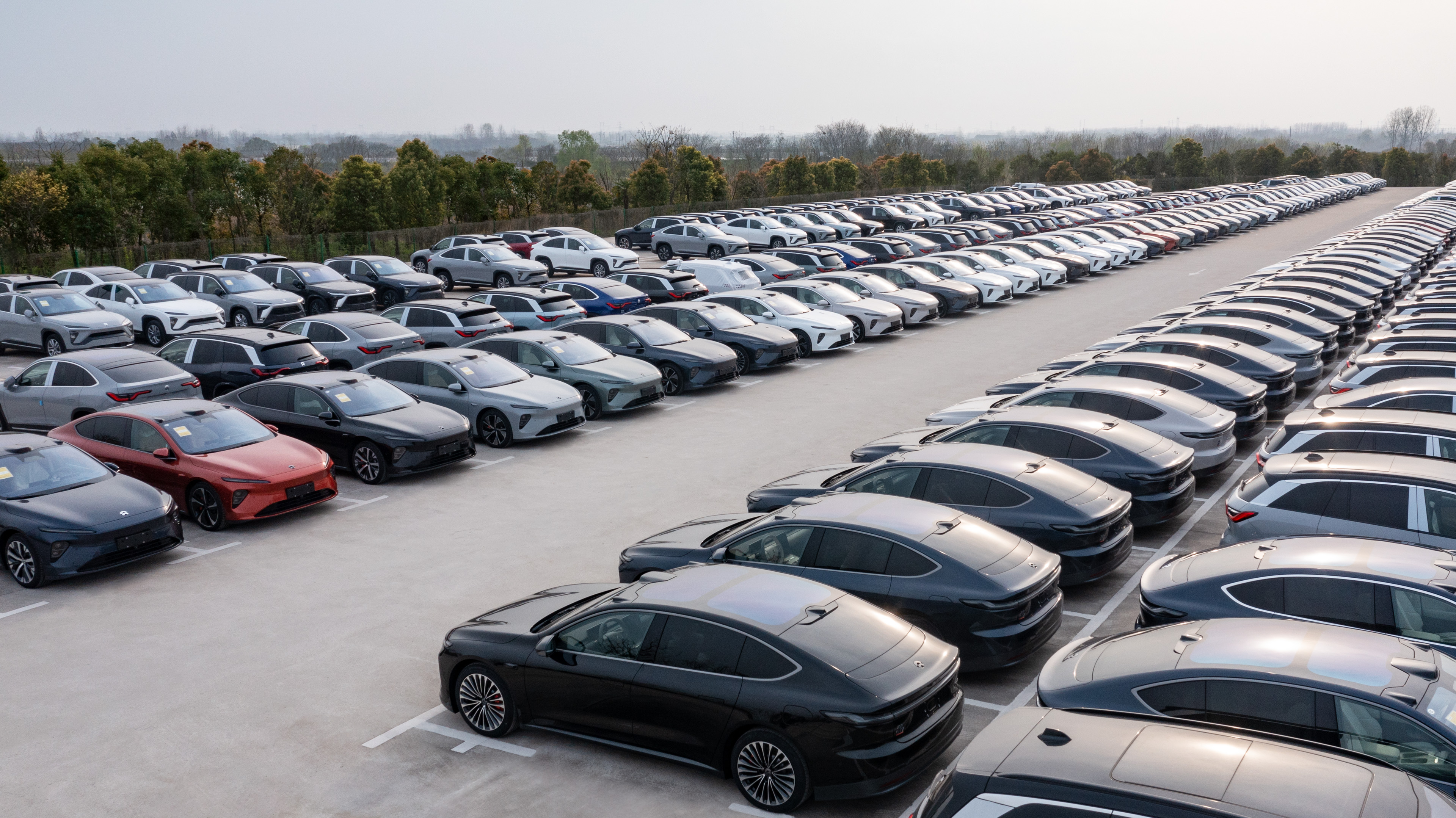 Nio's ET7 sedans lined up for deliveries in a parking lot.