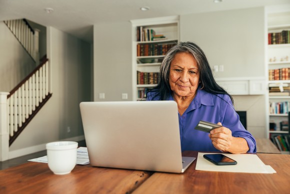 An online shopper holds a credit card while buying online.