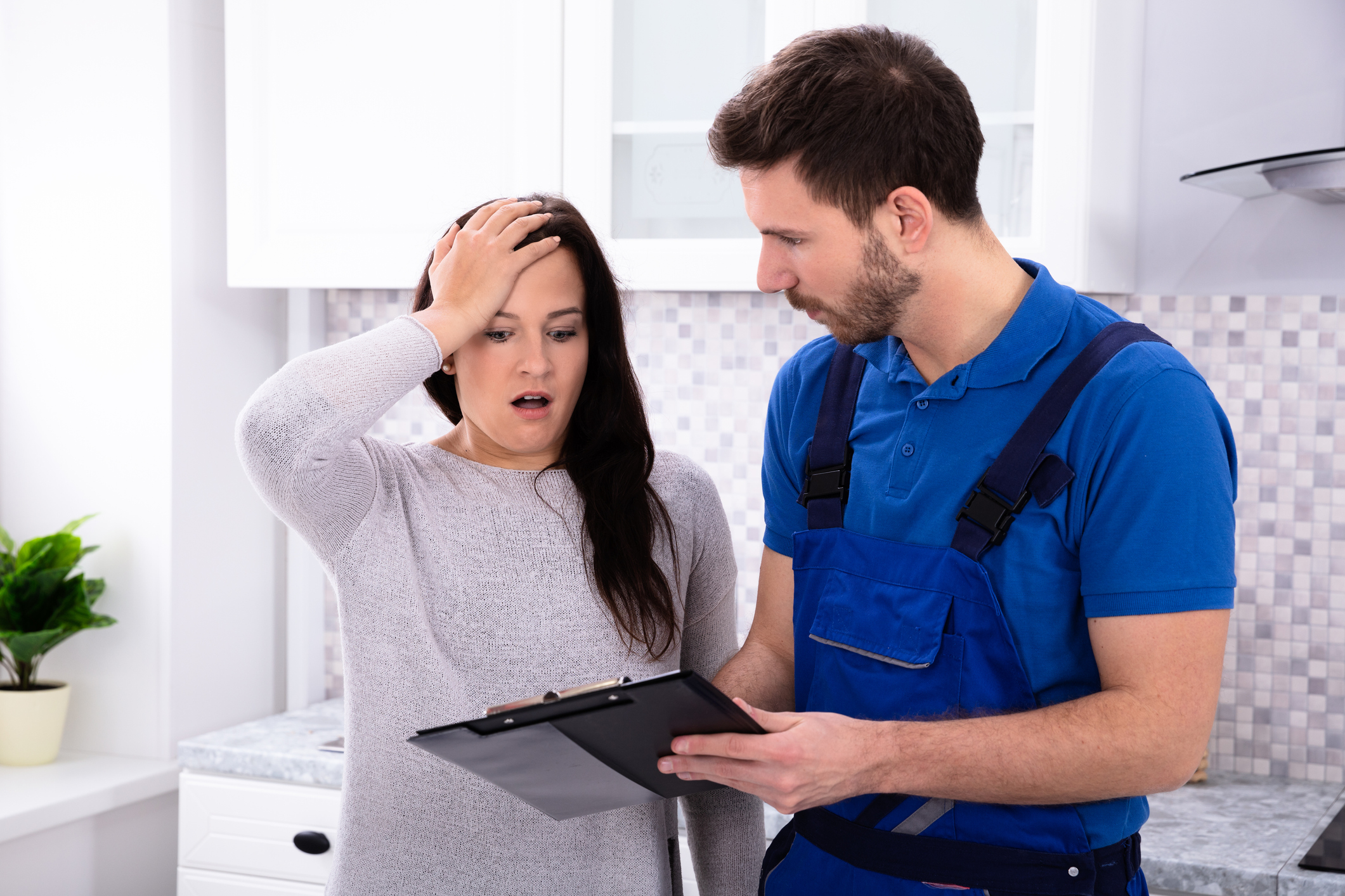 Two people looking at a clipboard in astonishment.