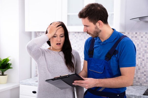 Two people looking at a clipboard in astonishment.