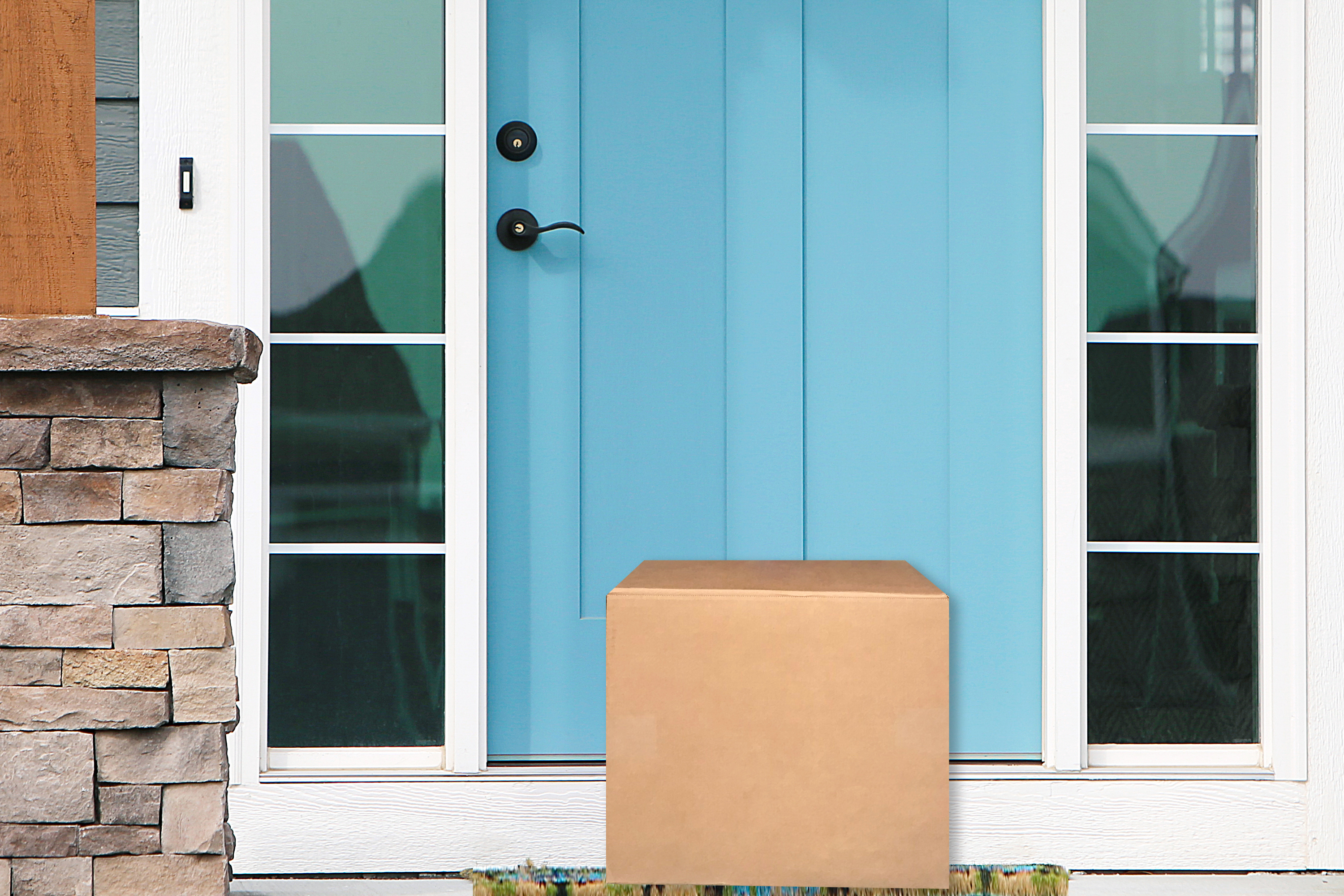 A package in front of a blue door of a house.