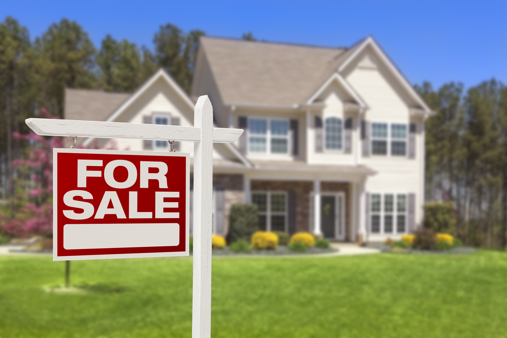 Two-story home with For Sale sign out front.