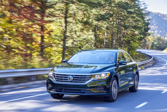 A 2022 Volkswagen Passat driving down a windy road. 