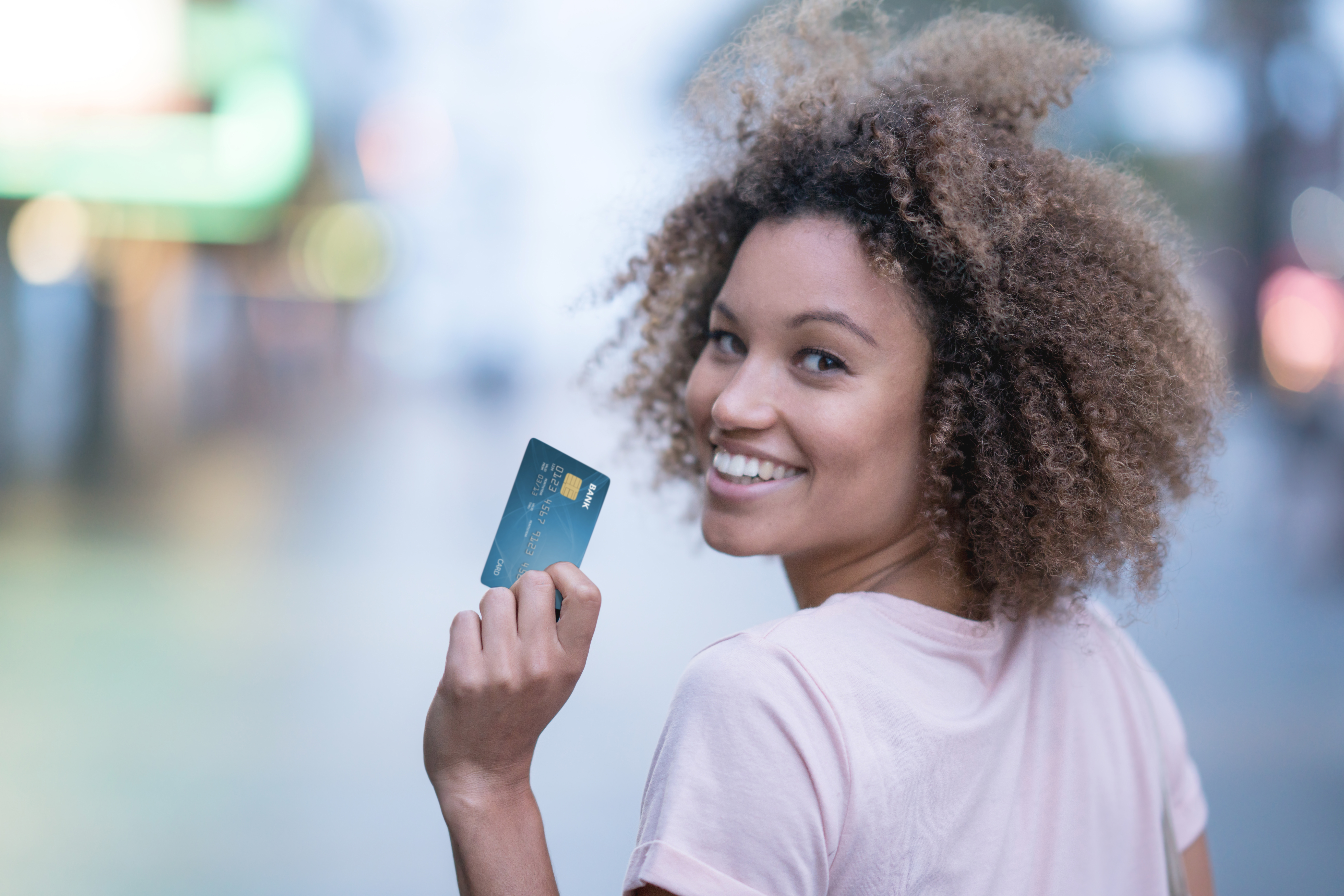 A woman holding up a credit card