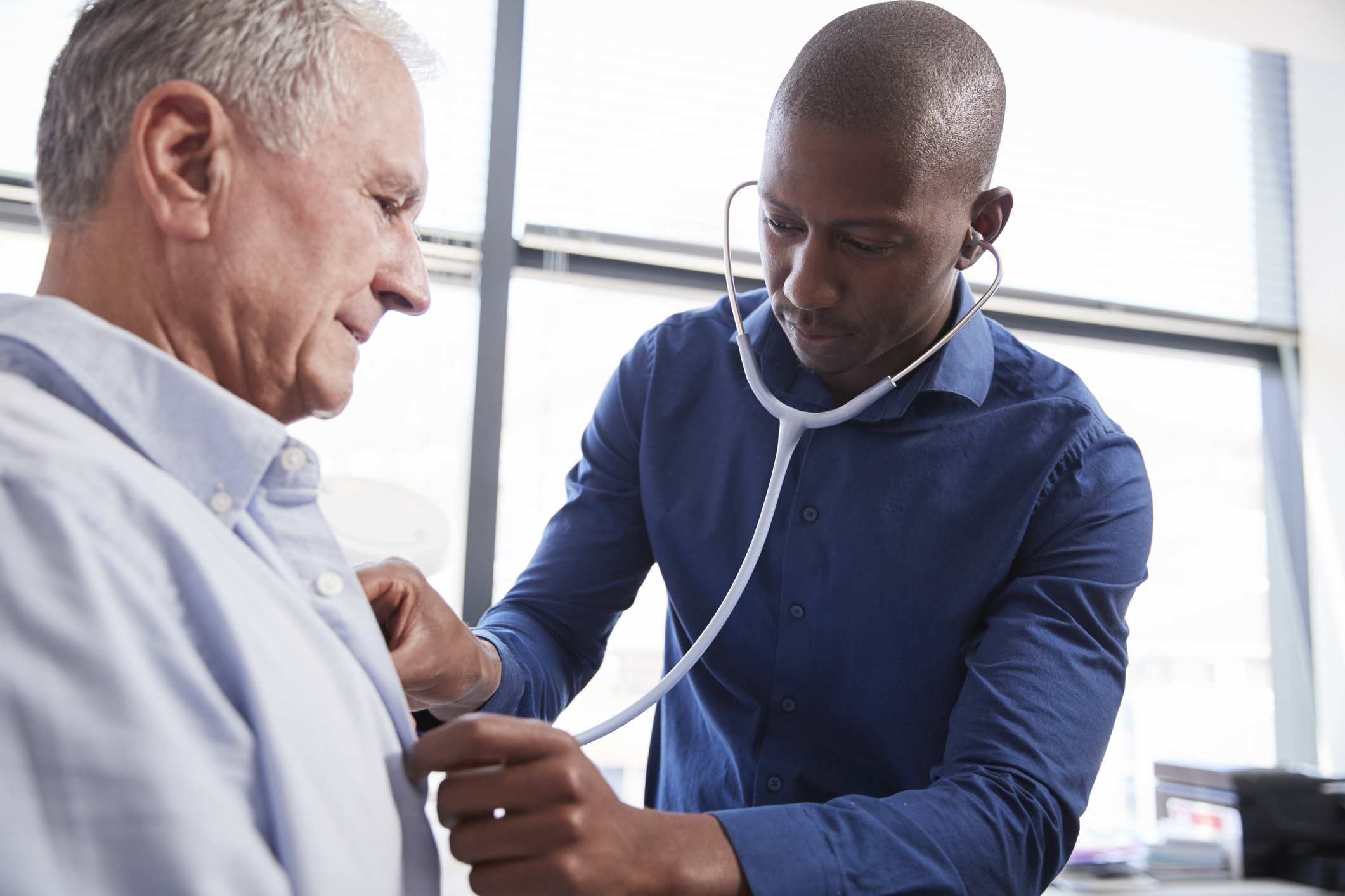 One person examining another with a stethoscope.