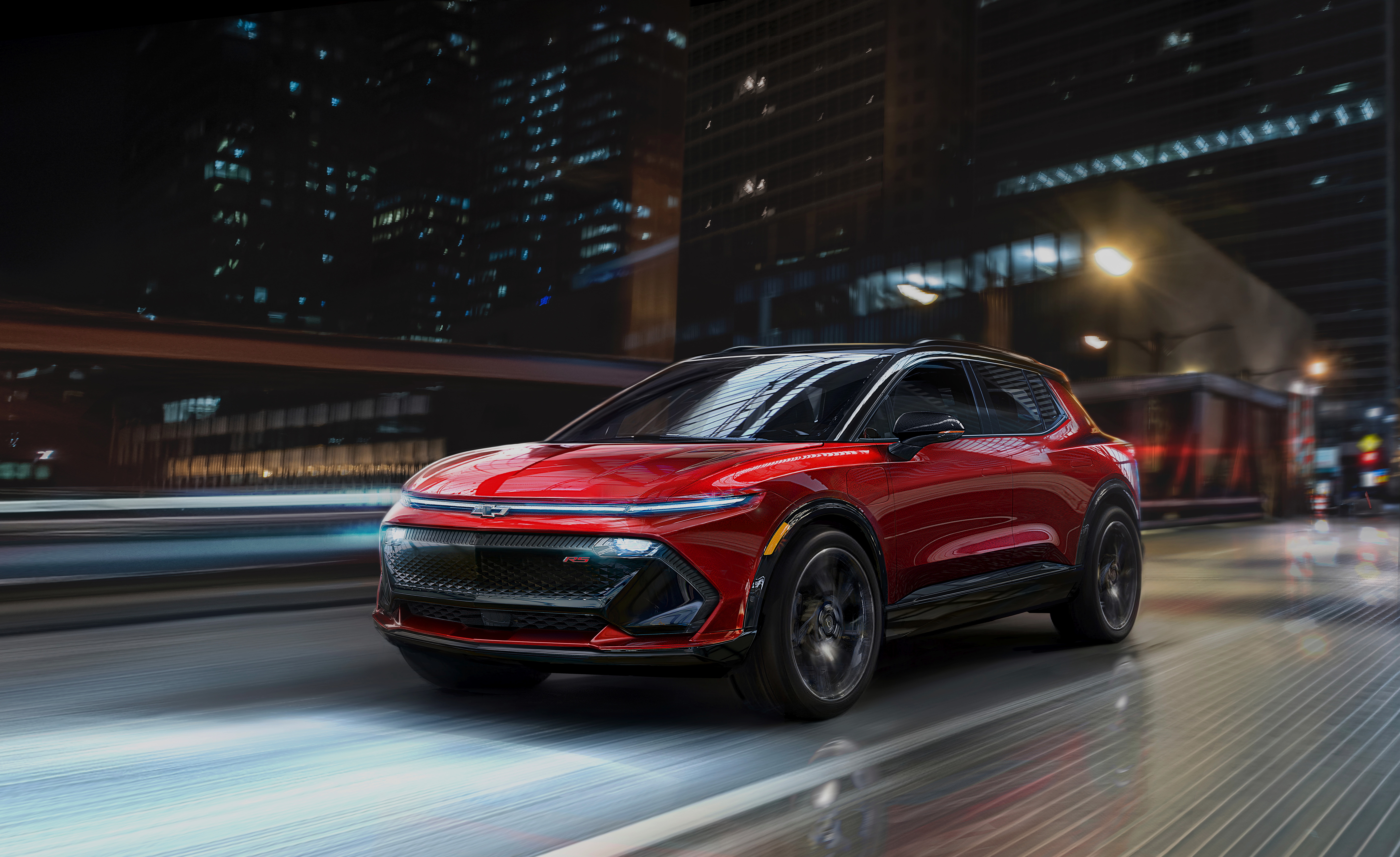 A red 2024 Chevy Equinox EV driving down a city street.
