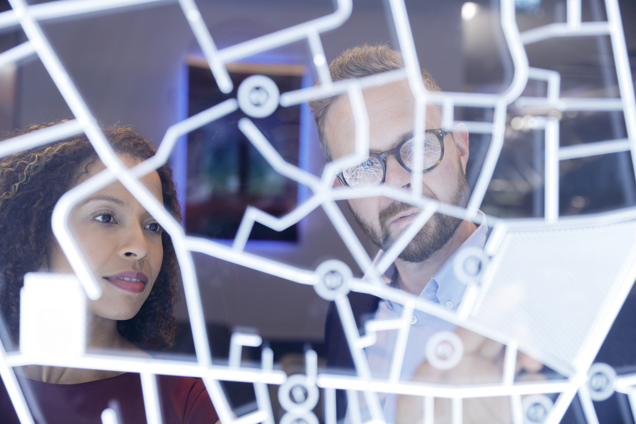 Two people looking at a data visualization on a wall.