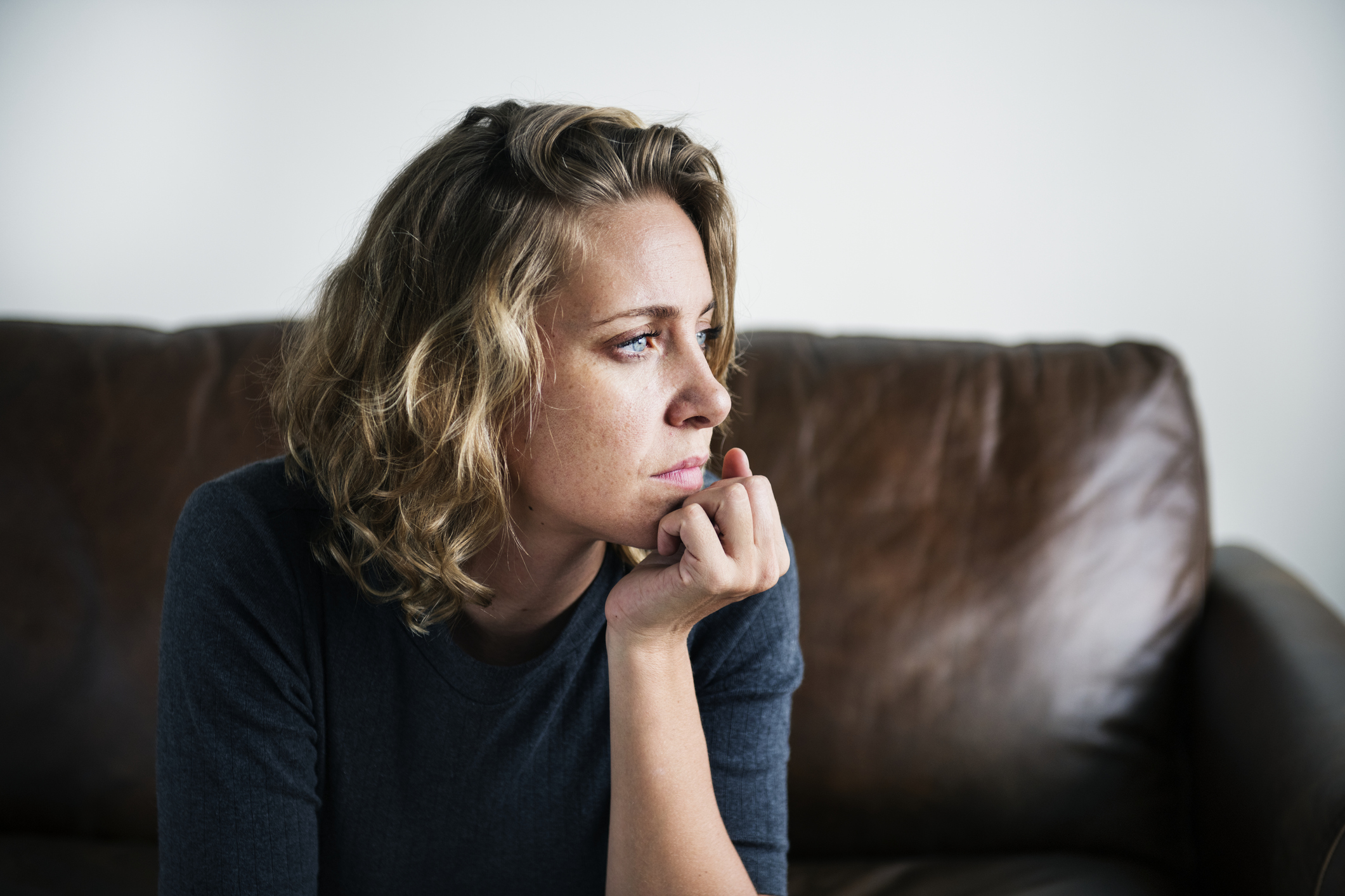 A person sitting on a couch and pondering a serious question.