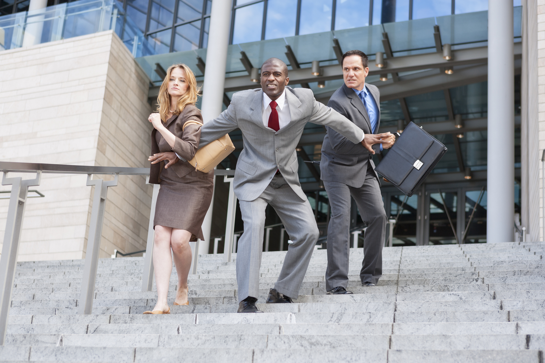 Man holding two other people back.