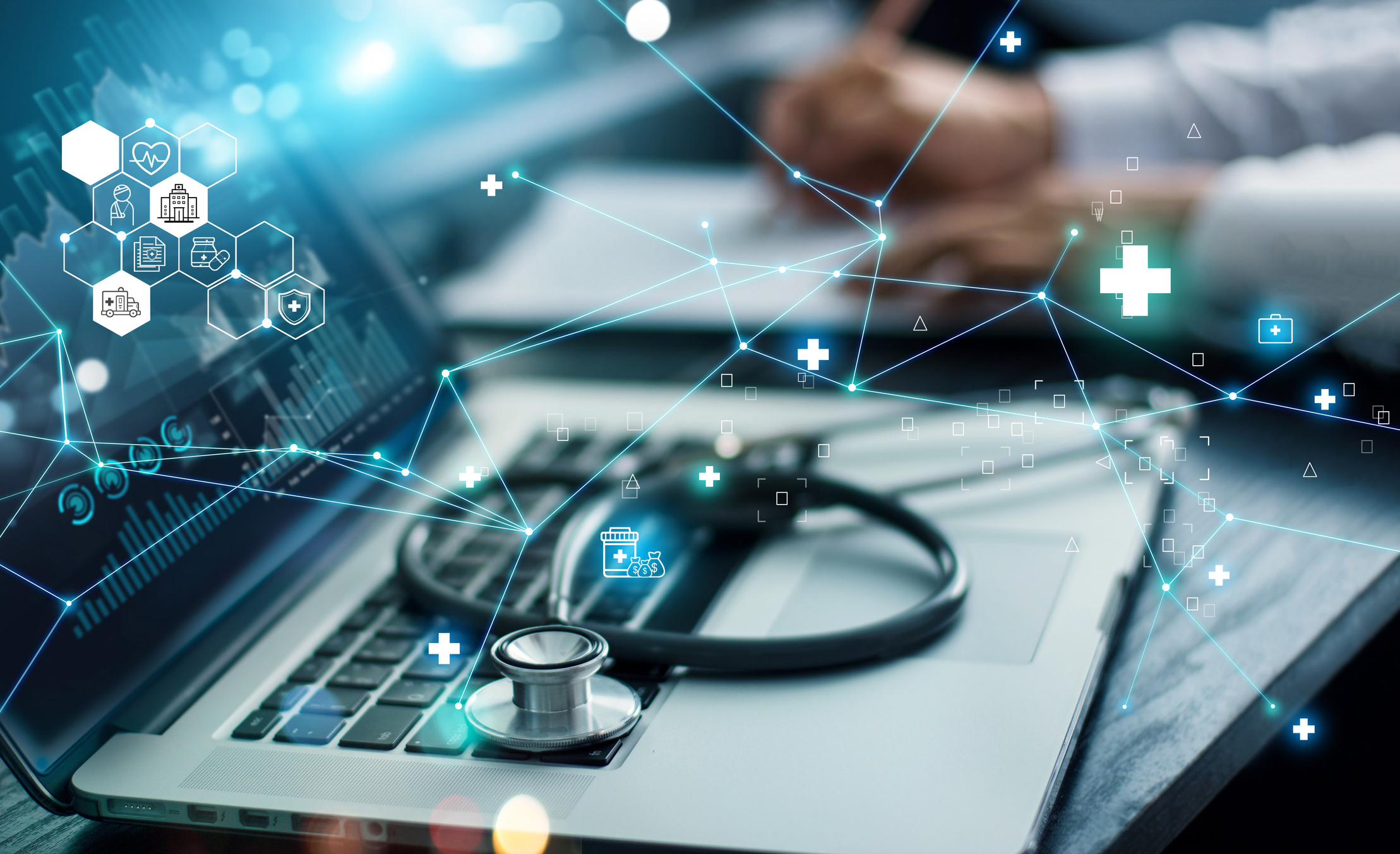 A laptop, a stethoscope, and lighted images in the foreground.