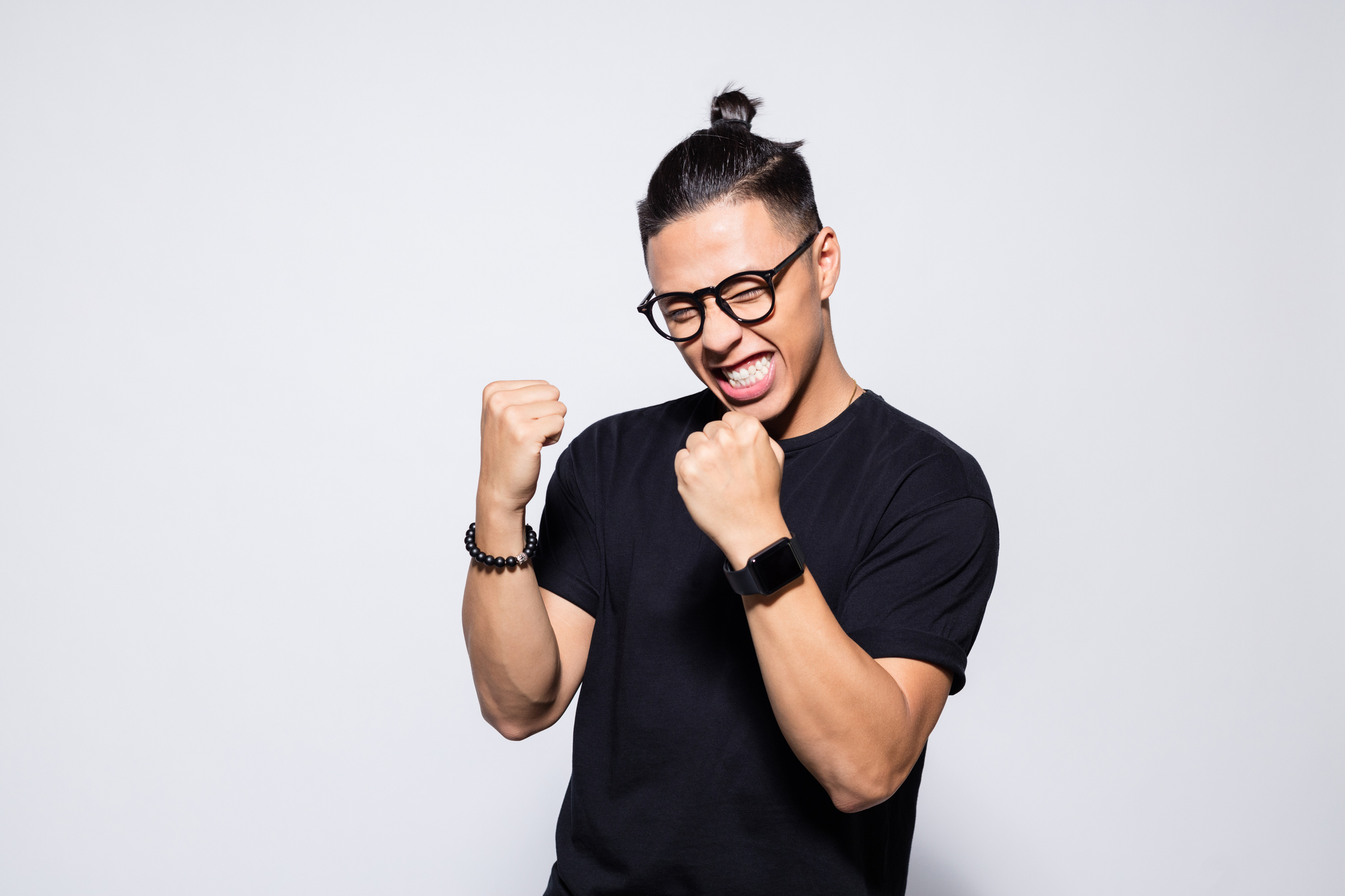 An excited person is making fists and smiling.