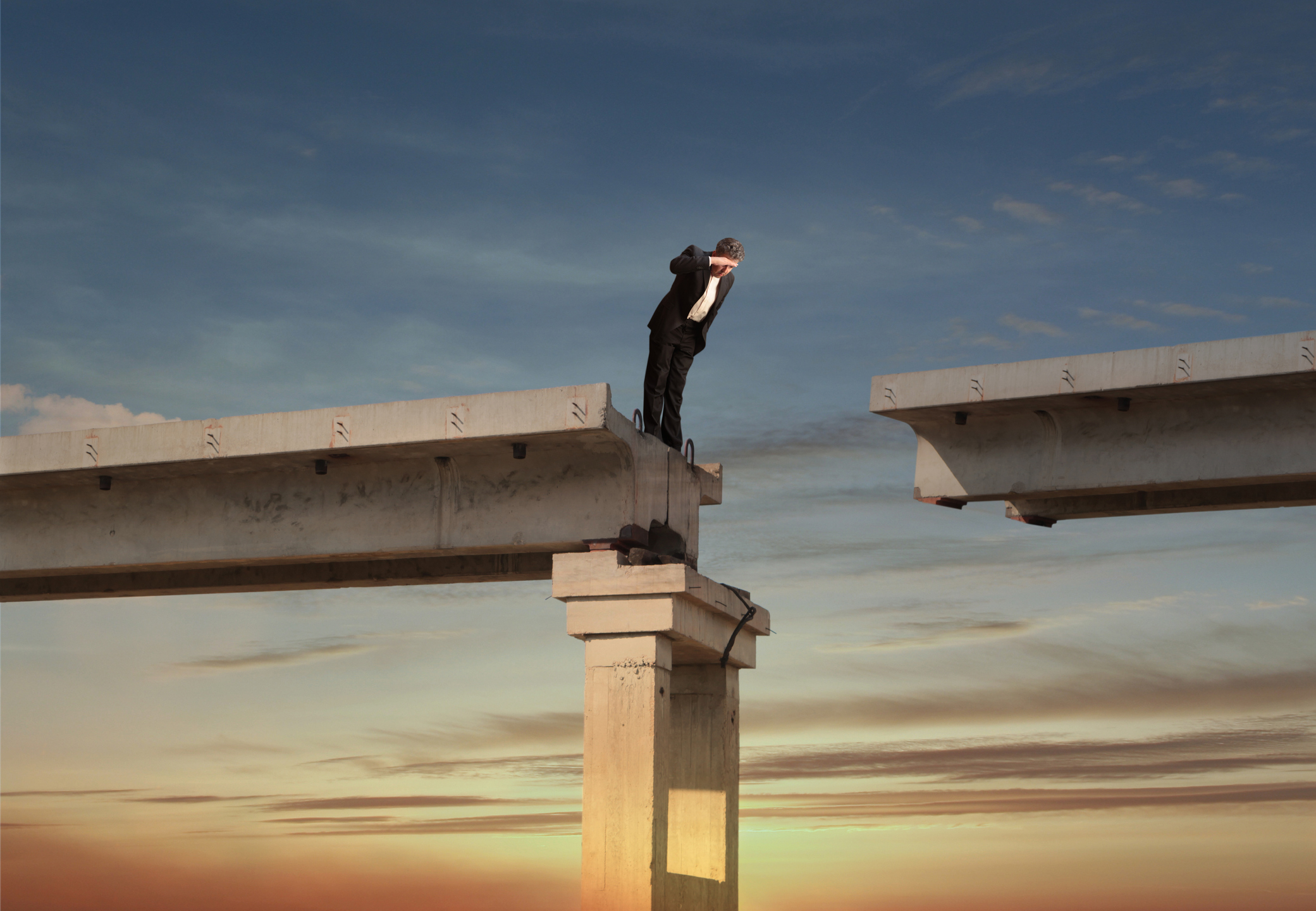 Person looking over the edge of a bridge.