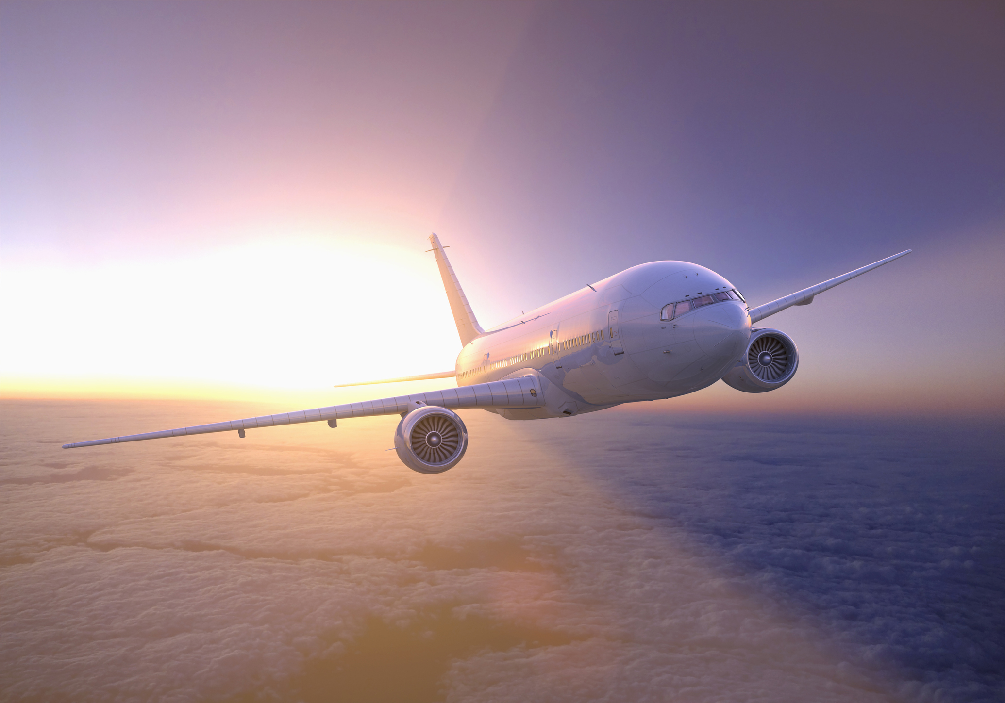 Airplane flying above clouds at sunset Getty