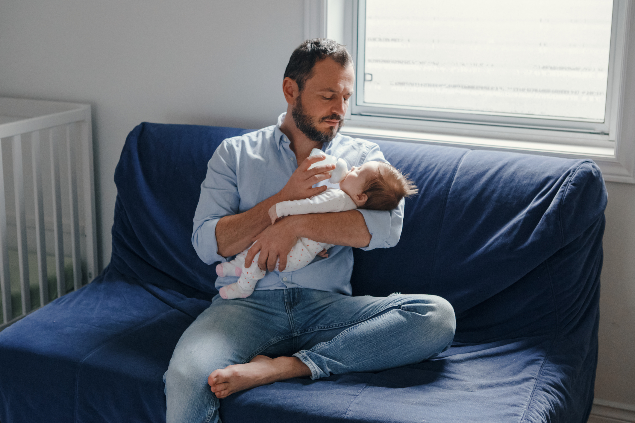 man feeds baby from bottle