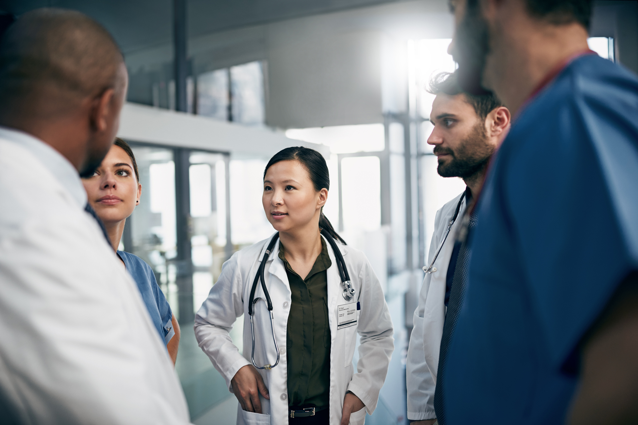 Medical professionals are talking while gathered in a circle.