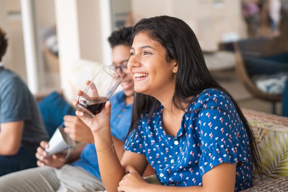 A person drinking a glass of cola.