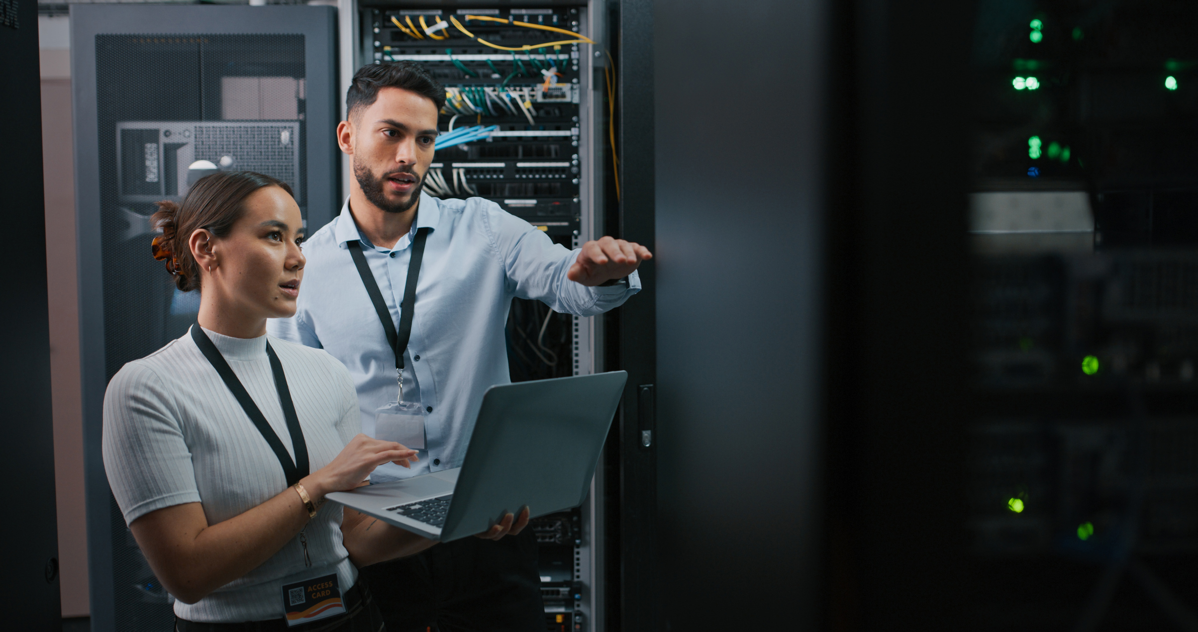 Two IT technicians examine computer servers.
