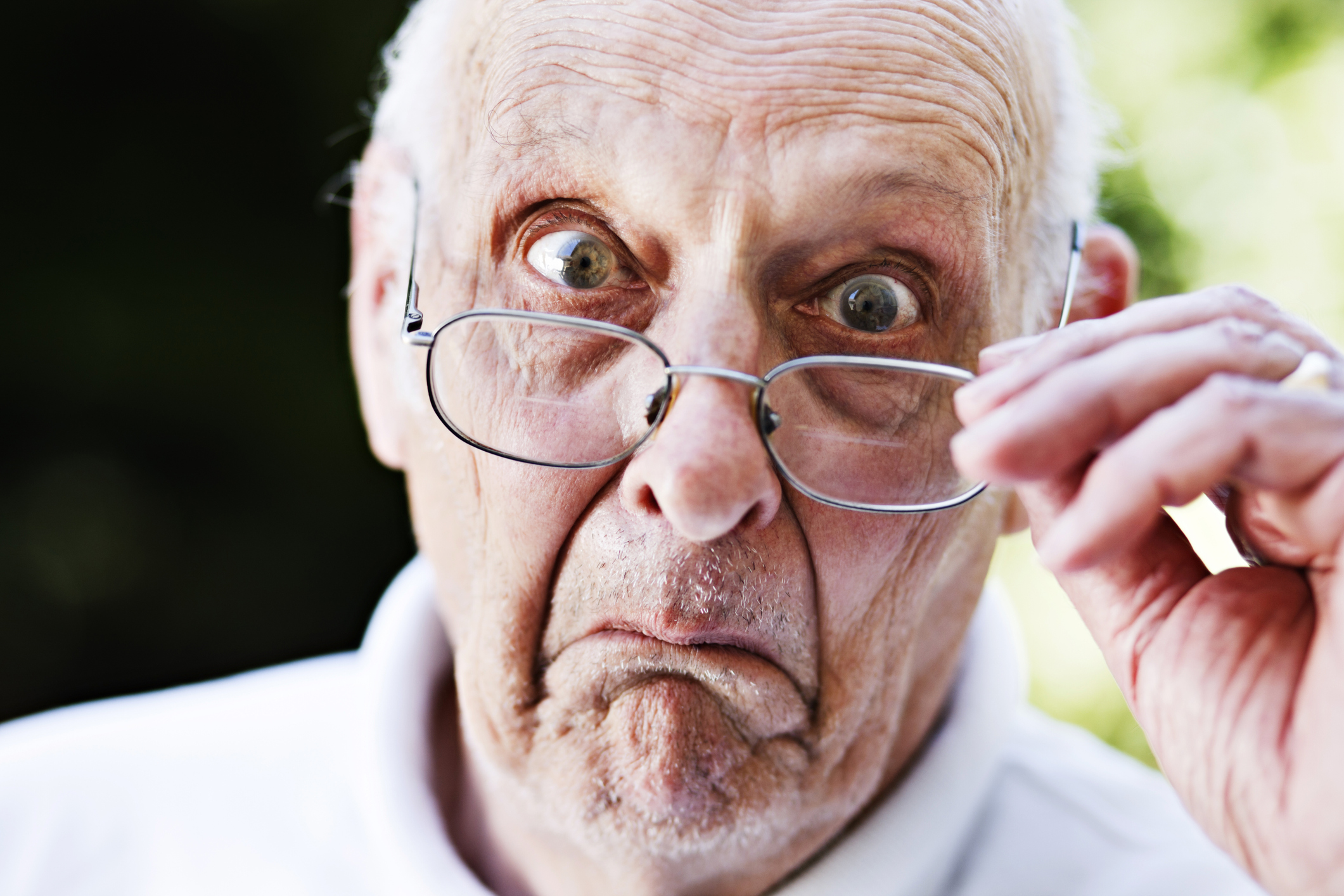 Someone is looking surprised or skeptical, pulling their glasses off.