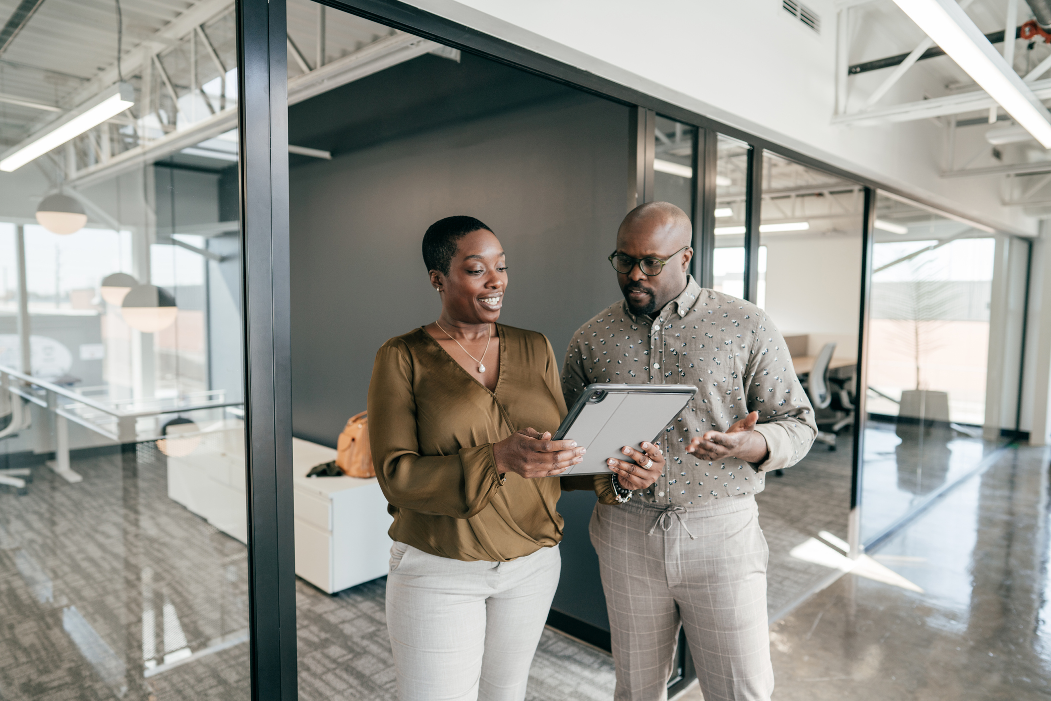 Two people standing and talking in some very modern-looking office space.