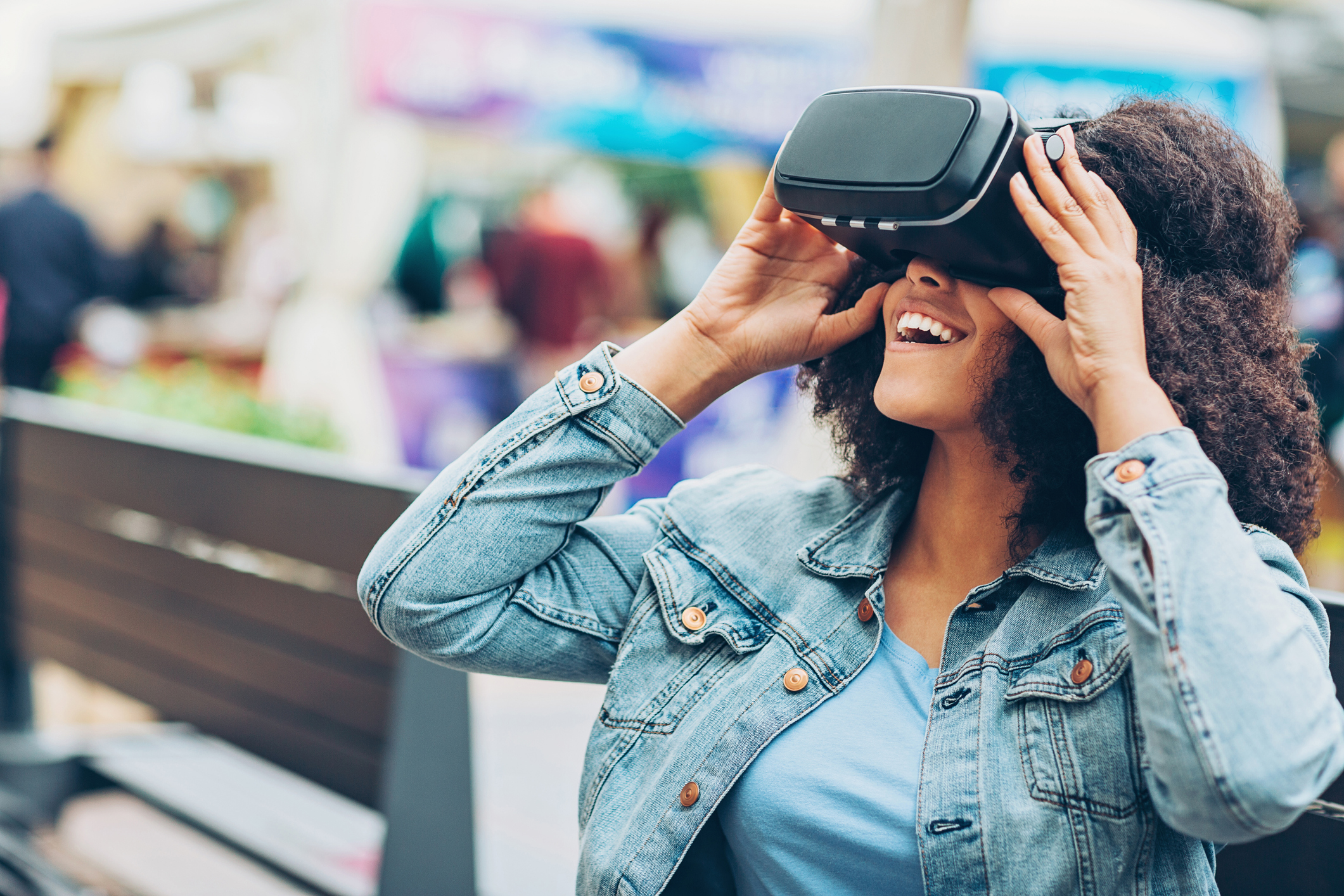 A person looks into a virtual reality viewer and smiles.