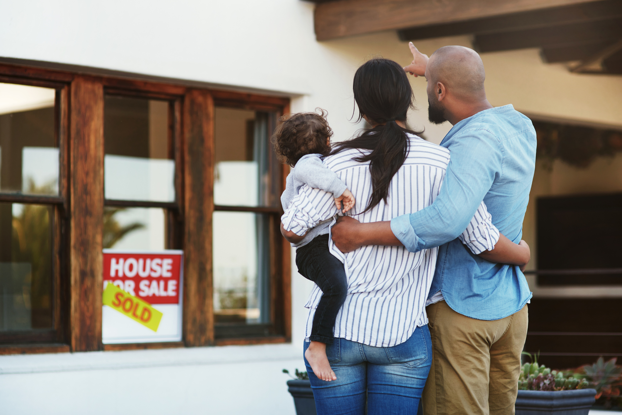 A family stands in front of a sold home.