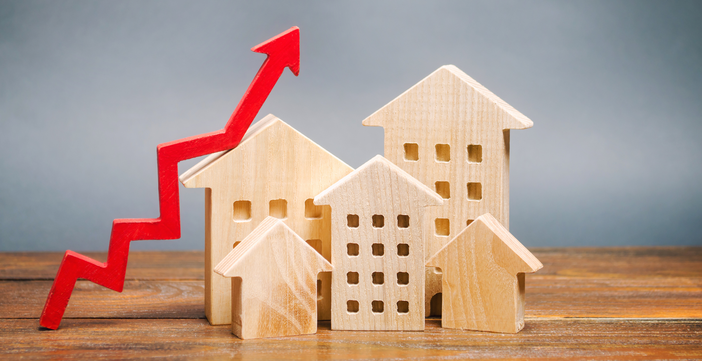 Red line with arrow trending upward next to wooden houses.