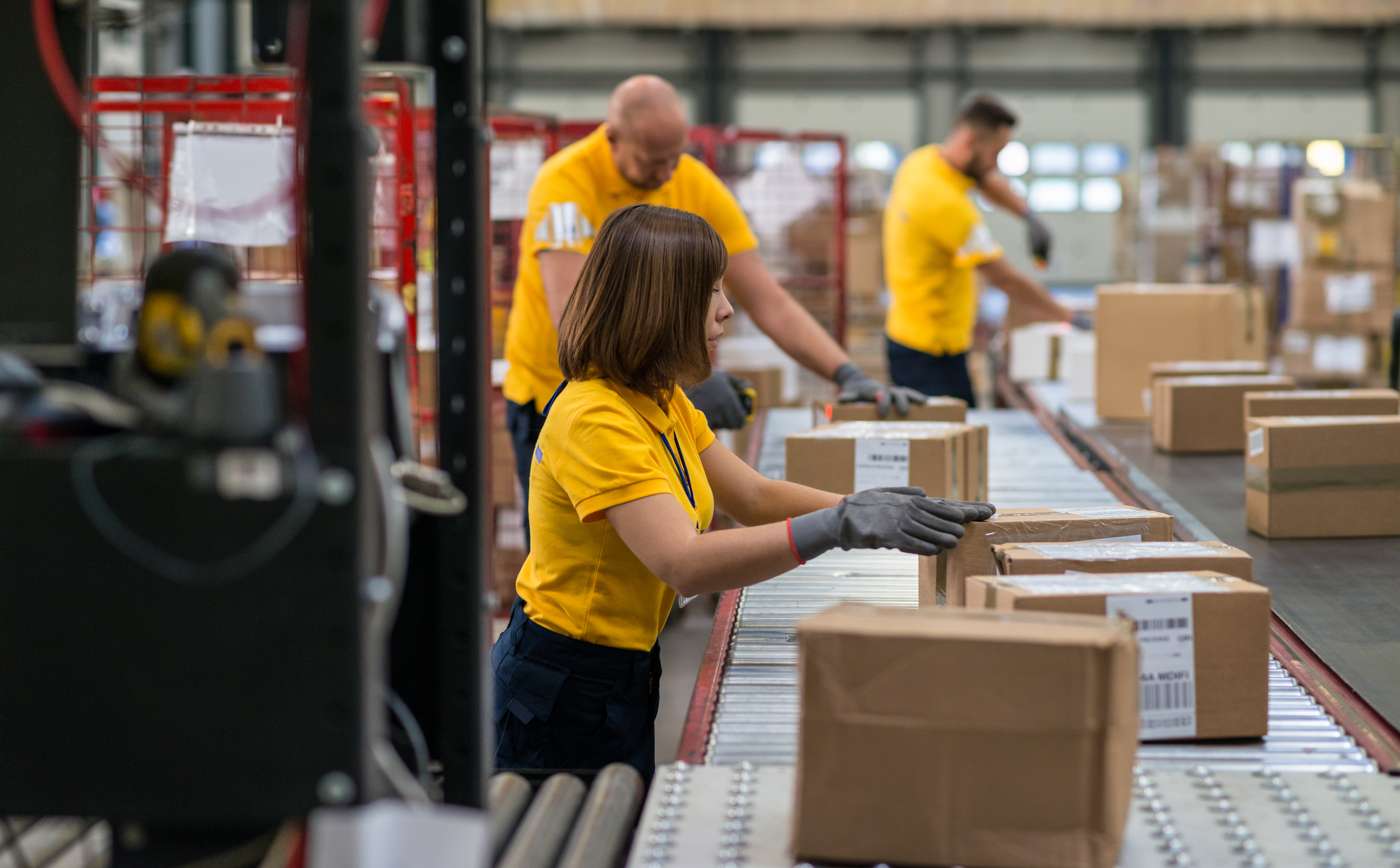 Workers sorting packages on a sorting line.