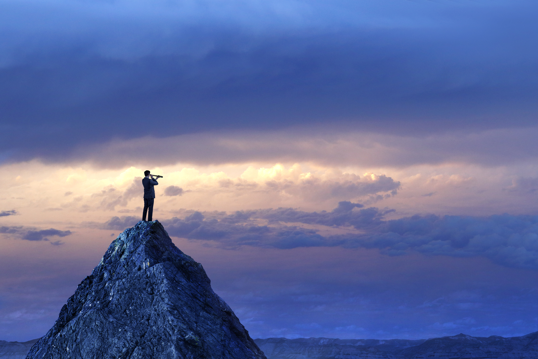 Person on top of mountain with telescope.