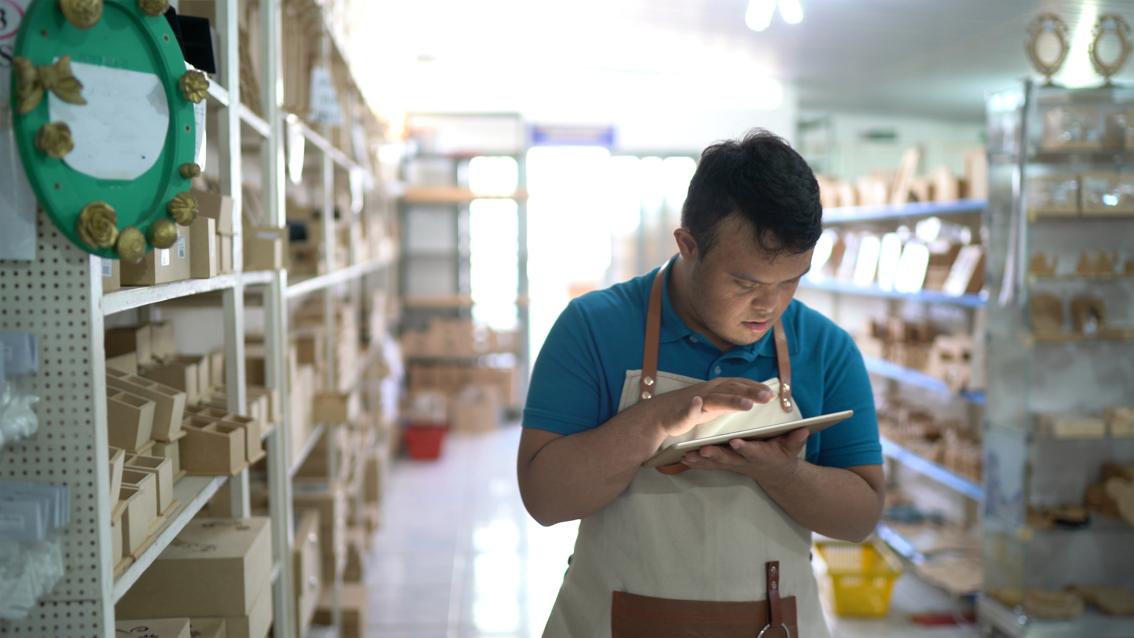 An employee looking at a tablet in a store.