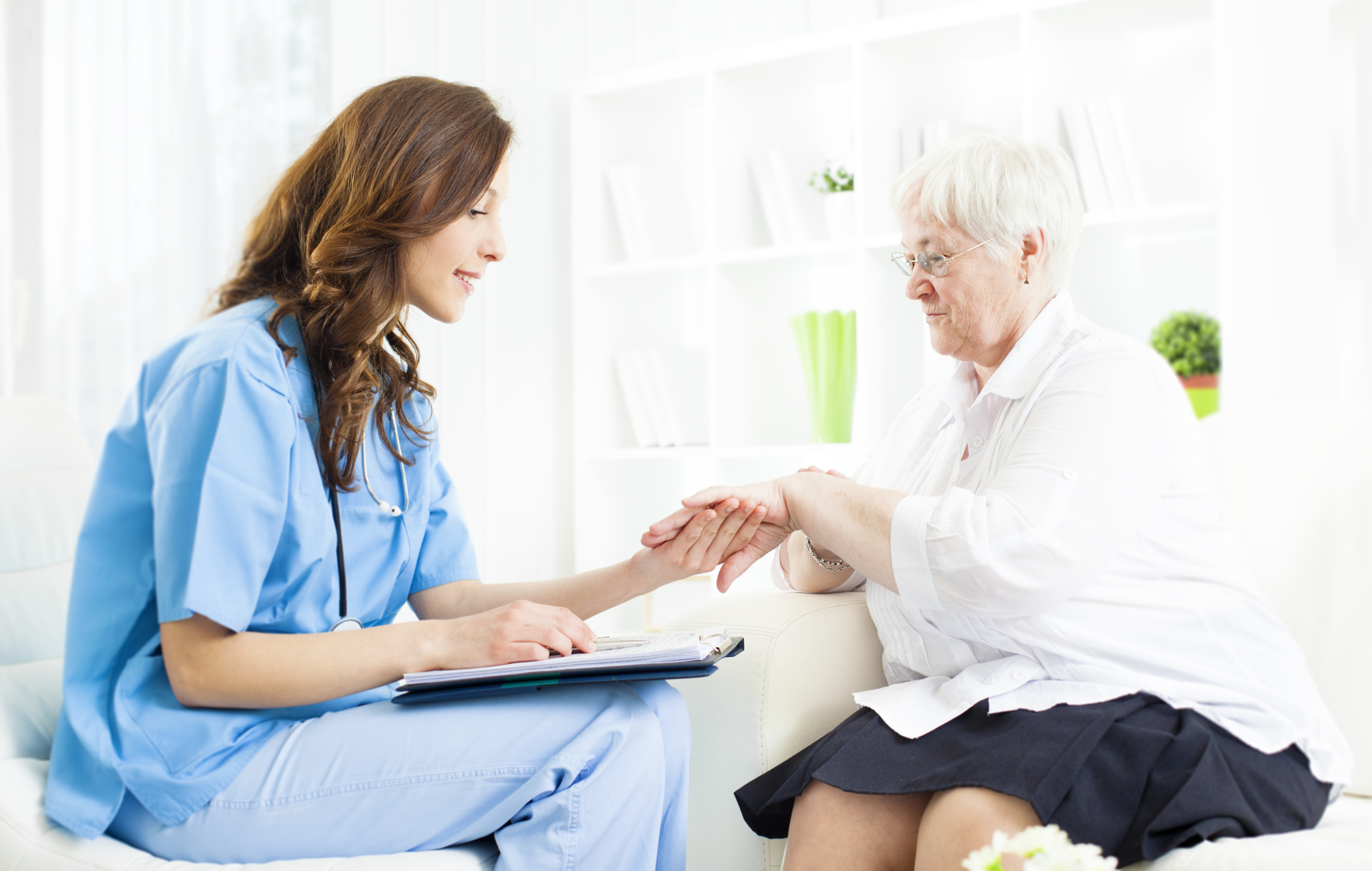 medical professional looking at hand of patient