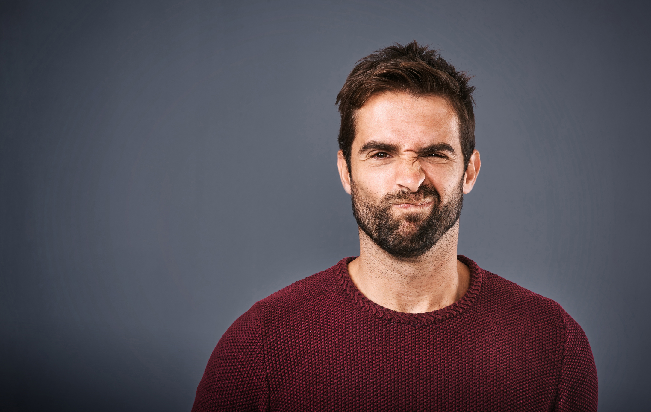 A person scrunching up his face, seemingly in doubt.