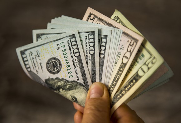 Hand holding fan of cash.