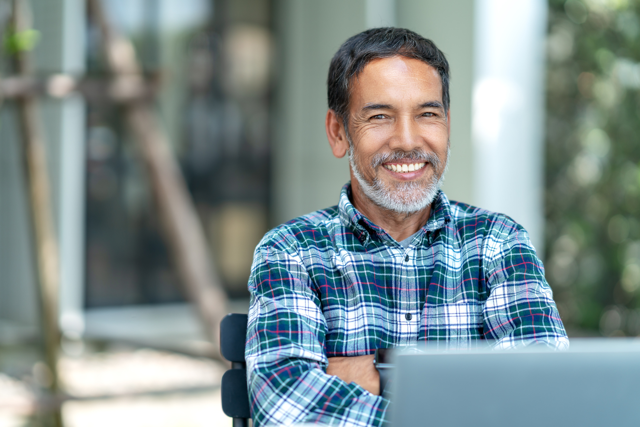 A smiling person at a laptop.